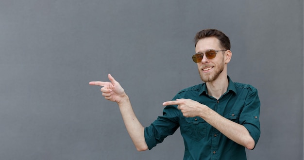 A young man gestures in the direction where the place for the inscription or banner is located