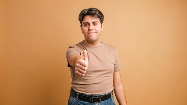 Photo young man gesturing agreement with thumb up
