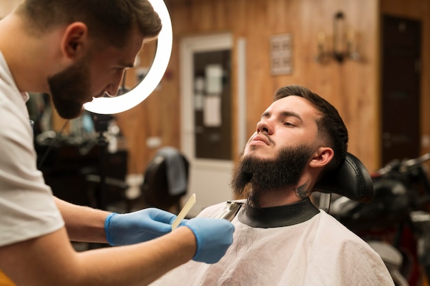 Молодой человек получает свою бороду в парикмахерской