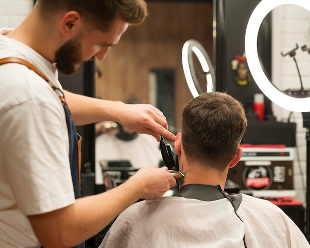 Молодой человек делает новую стрижку в парикмахерской