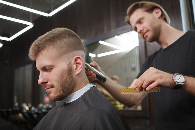 Young man getting new haircut at barbershop