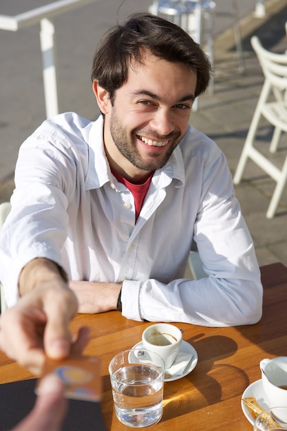 Young man giving credit card for payment at restaurant