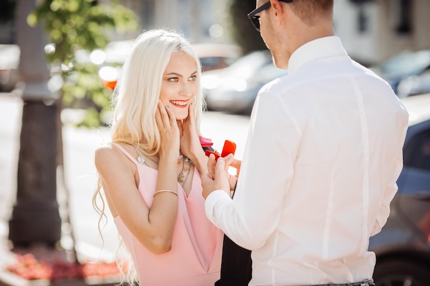 写真 若い男性が女性に小さな赤いボックスでダイヤモンドの婚約指輪を与える