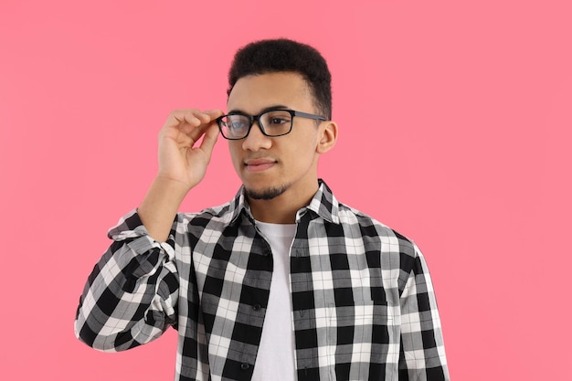 Photo young man in glasses on pink background