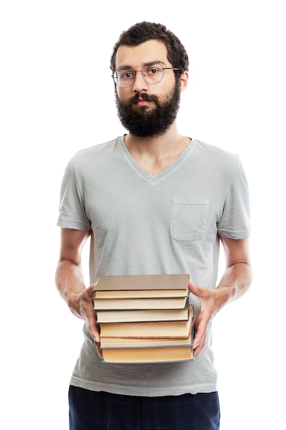 Giovane uomo con gli occhiali e con la barba con i libri in mano. istruzione e formazione.