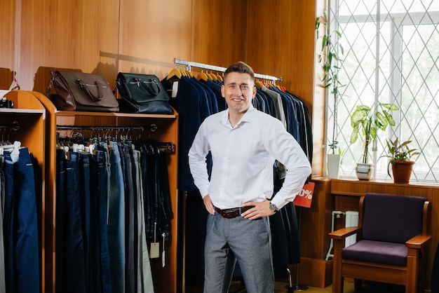 A young man goes shopping and picks up a man's suit.