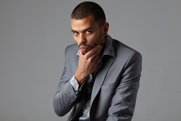 Young man in a gray blazer posing