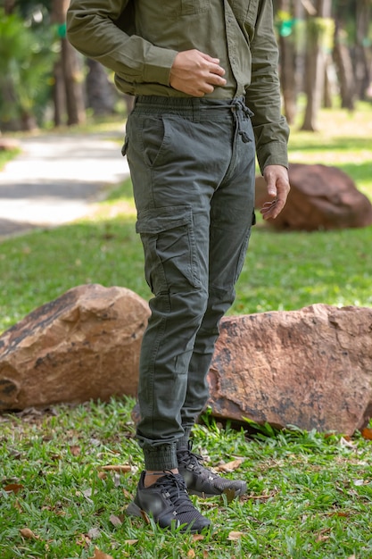 Young man in green pant standing  in the park