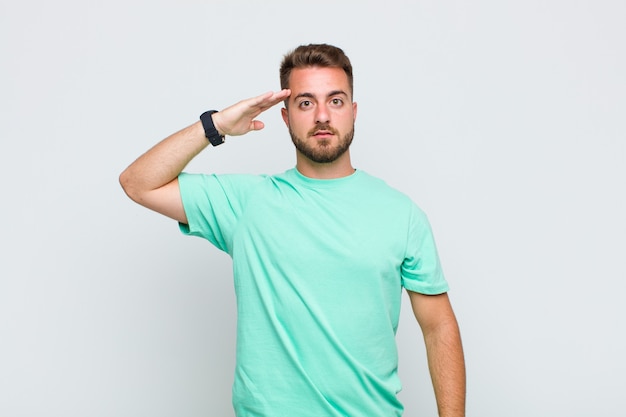 Young man greeting the camera with a military salute in an act of honor and patriotism, showing respect