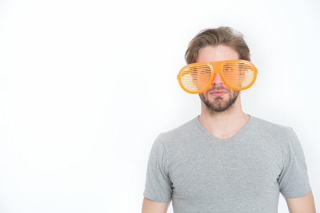 Young man in grey shirt with funny orange big glasses