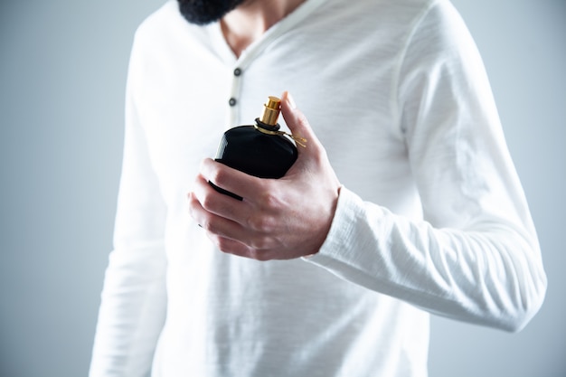 Young man hand holding perfume