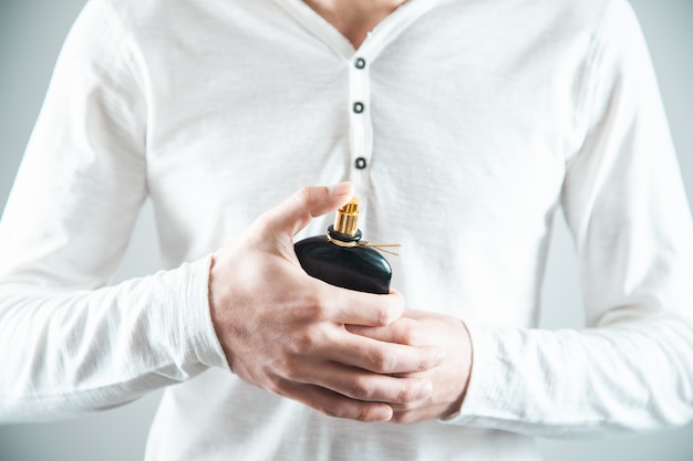 Young man hand holding perfume