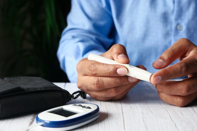 Young man hand measuring diabetic on table