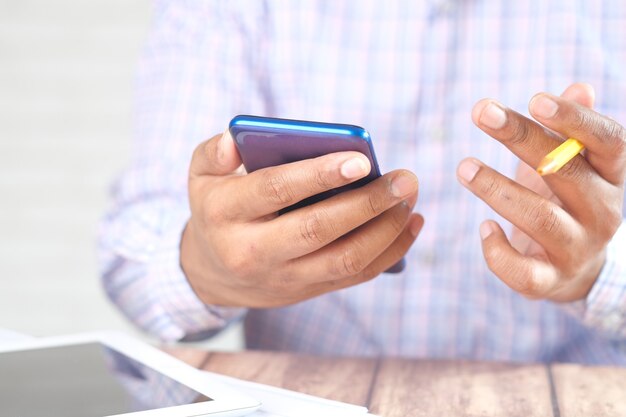 young man hand using smart phone while sited on chair