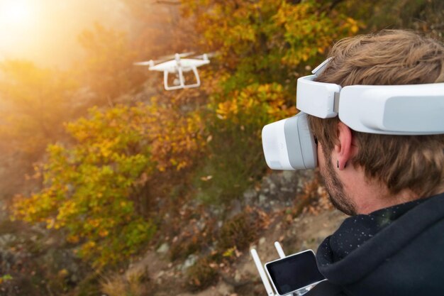 Young man handling drone using virtual reality glasses