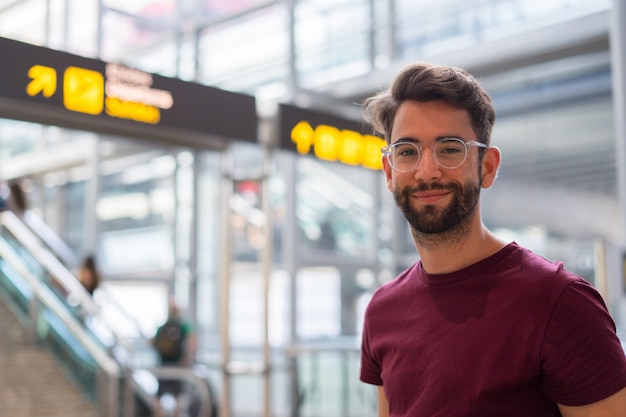 Giovane uomo felice e ridendo in aeroporto