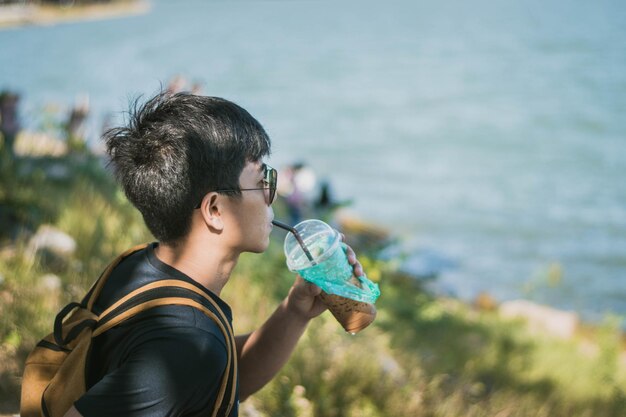 写真 海辺で酒を飲んでいる若い男