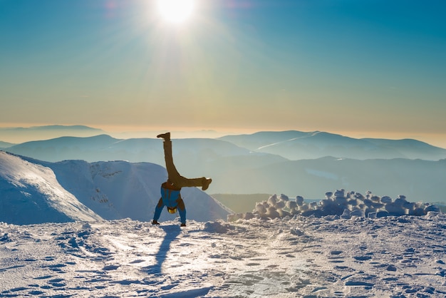写真 山の雪の上で楽しんでいる若い男