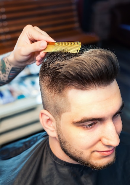Young man having hair cutted