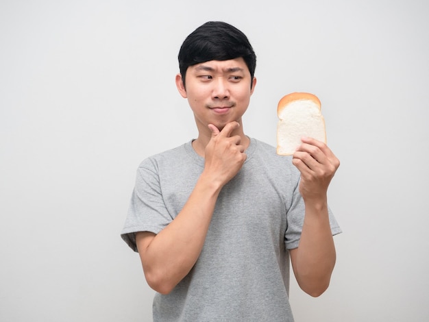 Young man hesitate to eat bread in hand