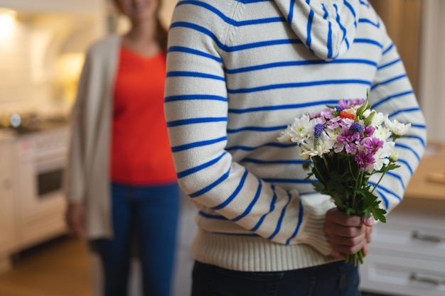 Young man hiding a flower bouquet behind his back