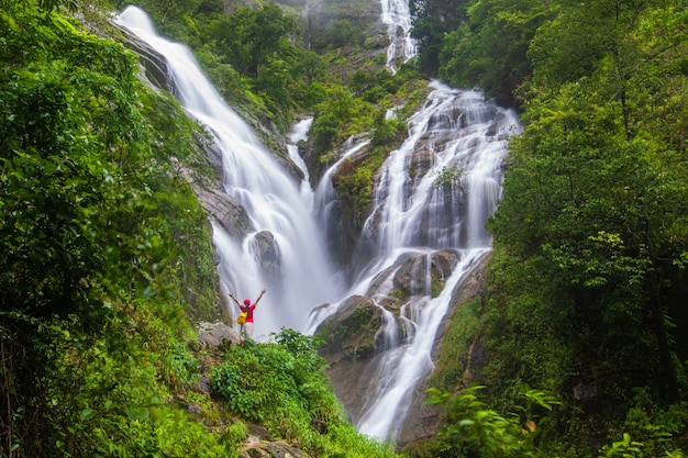 Photo young man hiking near the waterfall