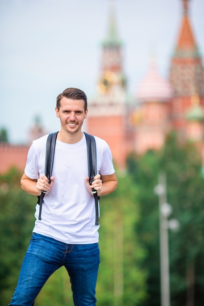 Young man hiking smiling happy portrait. Male hiker walking in the city