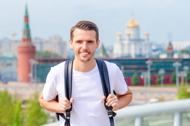 Young man hiking smiling happy portrait. Male hiker walking in the city