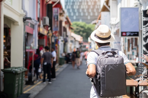Young man hipster traveling with backpack and hat