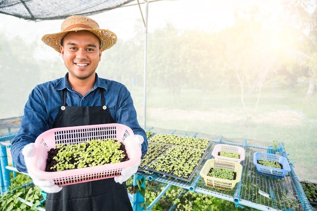 写真 小さな緑の植物有機野菜水耕栽培農場を保持している若い男