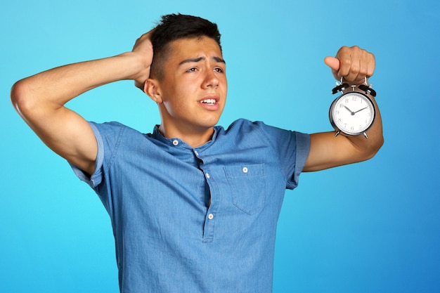 Young man holding an alarm clock