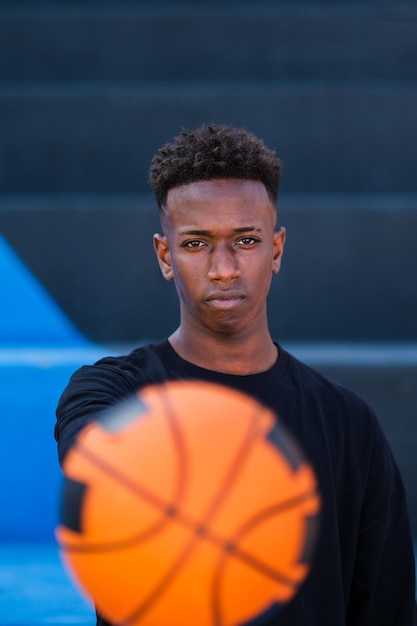 Молодой человек держит баскетбольный мяч на красочном фоне