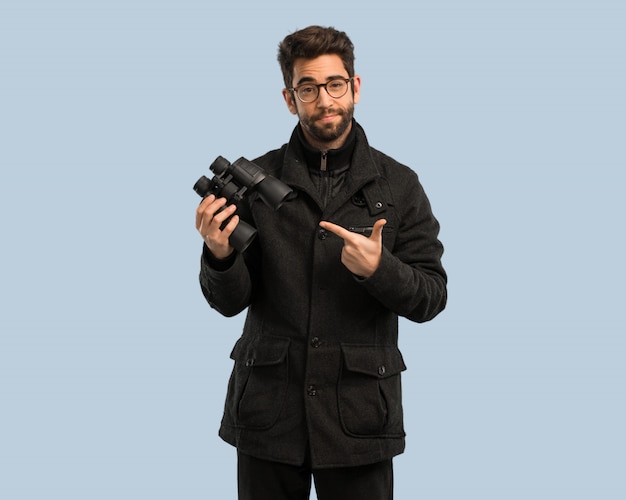 Young man holding a binoculars