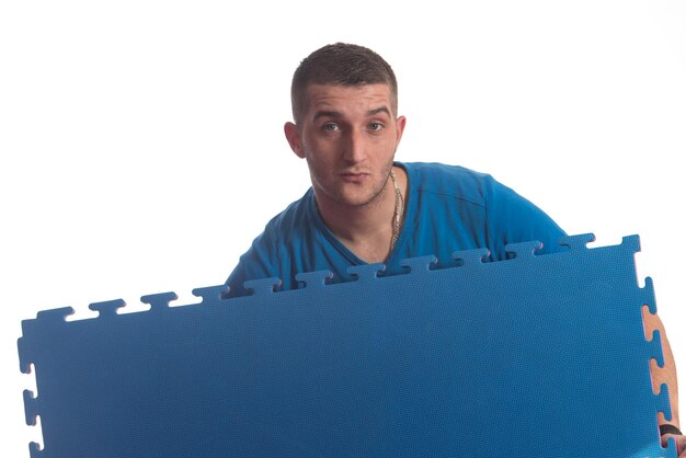 Young Man Holding Blue Tatami Mat Puzzle