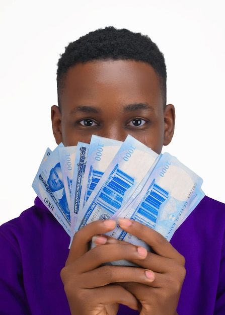 Foto un giovane con in mano un mucchio di nuove banconote nigeriane da 1000 naira