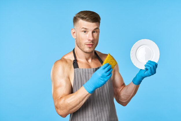 Young man holding camera against blue background