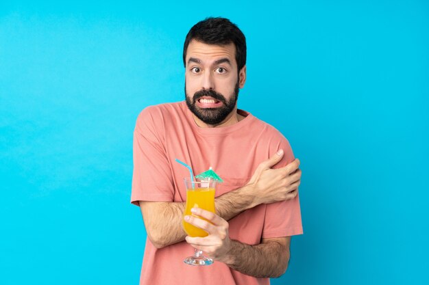 Young man over holding a cocktail over blue freezing