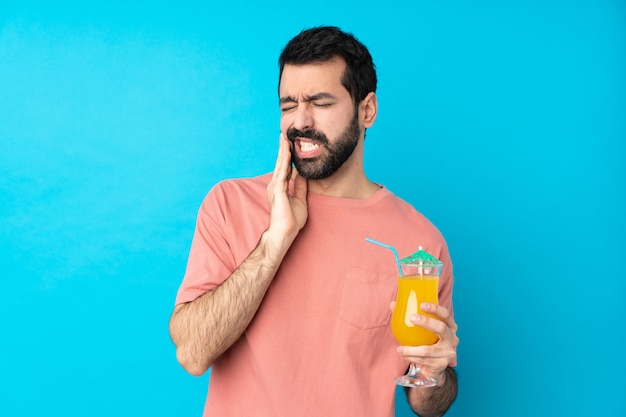 Young man over holding a cocktail with toothache