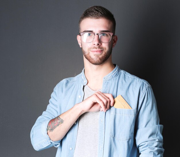 Young man holding a credit card standing