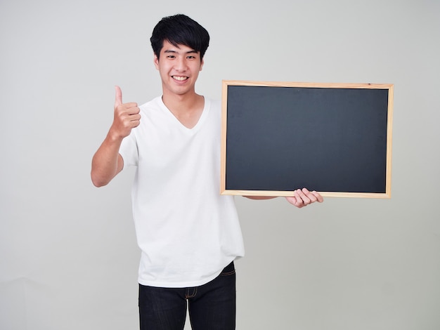 Young man holding empty blackboard