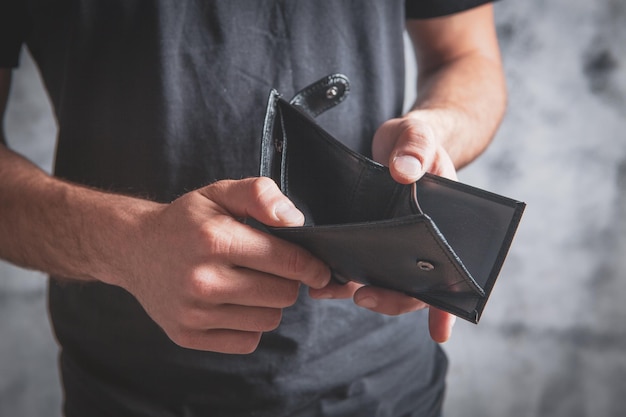 Young man holding empty wallet