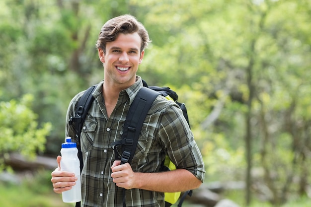 Young man holding energy drink in forest