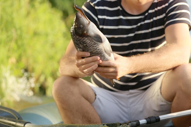 屋外で魚を保持している若い男