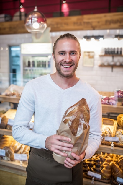 Young man holding a freshly baked bread