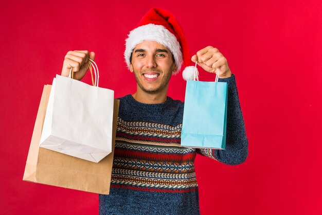 クリスマスの日に贈り物を持って若い男