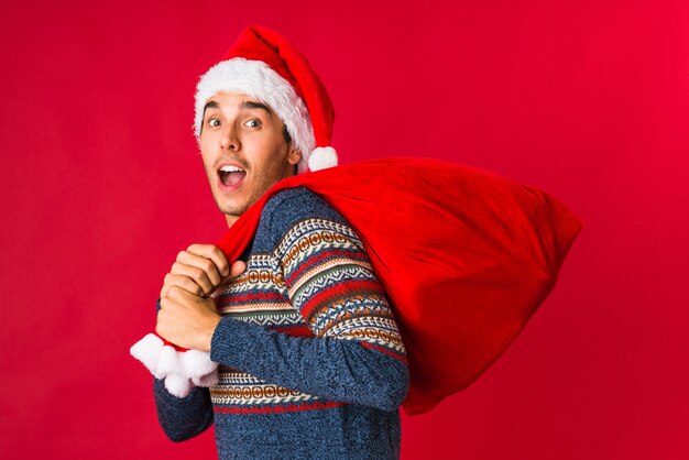 Young man holding a gift on christmas day