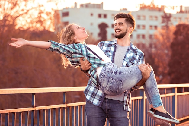 Young man holding girl in his arms