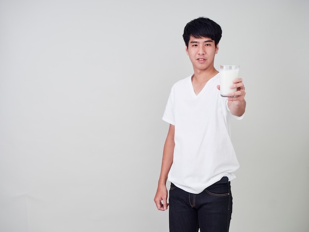 Young man holding glass of fresh milk.