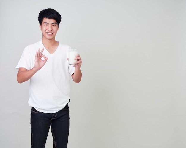 Young man holding glass of fresh milk.