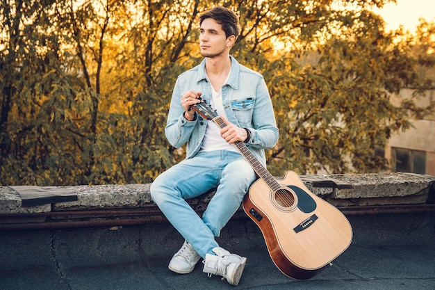 dramatic young guitarist looking back while holding guitar on sh Stock  Photo | Adobe Stock